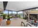 Screened in patio with fireplace, seating area, and view of the canal and foliage at 10432 Sandpiper W Rd, Bradenton, FL 34209
