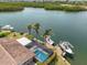 Backyard view of caged pool, with dock, boat lift, and waterfront access at 10432 Sandpiper W Rd, Bradenton, FL 34209