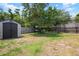Large backyard featuring a storage shed, privacy fence, and shady trees at 1052 32Nd St, Sarasota, FL 34234