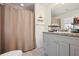 Bathroom featuring tile floors, shower with curtain and grey vanity at 1052 32Nd St, Sarasota, FL 34234