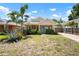 Charming single-story home with a bright blue door, well-kept landscaping, and a brick driveway at 1052 32Nd St, Sarasota, FL 34234