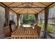 Covered outdoor patio featuring dining table, chairs, and adjacent yard at 1052 32Nd St, Sarasota, FL 34234