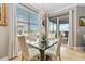 Cozy dining area with glass table, elegant chandelier, and natural light from large windows at 1109 Riverscape St, Bradenton, FL 34208