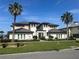 Beautiful two-story home featuring a well-manicured lawn and lush landscaping with lovely palm trees at 1109 Riverscape St, Bradenton, FL 34208