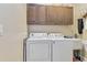 Functional laundry room with modern washer and dryer, plus ample cabinet space at 1109 Riverscape St, Bradenton, FL 34208