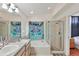 Bathroom featuring double sinks, walk-in shower, and tub with colorful curtain at 11236 Beebalm Cir, Lakewood Ranch, FL 34202