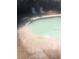 An inviting pool with lounge chairs sitting on cracked concrete and a wood fence in the background at 1127 Tyrone N Ct, St Petersburg, FL 33710