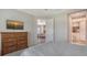 Cozy bedroom with view to en-suite bathroom featuring a wooden dresser and comfortable bed at 1203 Calle Grand St, Bradenton, FL 34209