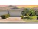 Charming home featuring a brick driveway, two-car garage and a well-manicured lawn with mature landscaping at 1203 Calle Grand St, Bradenton, FL 34209