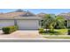 Exterior elevation featuring a well-manicured yard and a large paver driveway at 1203 Calle Grand St, Bradenton, FL 34209