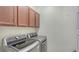 Laundry area equipped with front-loading washer and dryer, and overhead cabinets at 1203 Calle Grand St, Bradenton, FL 34209