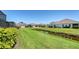 Manicured lawns, charming homes, and a scenic pond create an inviting neighborhood street view at 1203 Calle Grand St, Bradenton, FL 34209