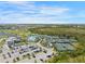 Expansive aerial view of the community featuring a pool, tennis courts, golf course, and residences at 12440 Wellen Golf St # 105, Venice, FL 34293