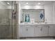 Modern bathroom featuring double sinks, a large mirror, and a sleek glass-enclosed shower at 12440 Wellen Golf St # 105, Venice, FL 34293