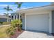 Attached garage in a well-manicured condo community with lush landscaping and palm trees at 12440 Wellen Golf St # 105, Venice, FL 34293