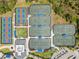 Overhead view of tennis and pickleball courts with blue accents and surrounding trees at 12440 Wellen Golf St # 105, Venice, FL 34293