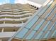 Detailed shot of the Bay Plaza exterior showing the glass canopy, wave-patterned balconies, and columns at 1255 N Gulfstream Ave # 402, Sarasota, FL 34236