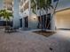 A community seating area features a table, lounge chairs, palm trees, and a hot tub at 1255 N Gulfstream Ave # 402, Sarasota, FL 34236