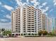 Exterior of a modern high-rise building with balconies and large windows under a sunny, partly cloudy sky at 1255 N Gulfstream Ave # 402, Sarasota, FL 34236