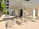 Community pool deck with lounge chairs and a shaded seating area at 1255 N Gulfstream Ave # 402, Sarasota, FL 34236