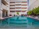 Stunning community pool with lounge seating and lovely landscape at 1255 N Gulfstream Ave # 402, Sarasota, FL 34236