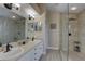 Bathroom with double sinks, granite countertops, and glass enclosed walk-in shower at 12805 Raysbrook Dr, Riverview, FL 33569