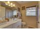 Bathroom featuring white cabinets, a mirror, a window, and a shower with curtain at 12805 Raysbrook Dr, Riverview, FL 33569