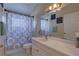 Bathroom featuring a shower-tub combo with blue decorative patterned curtain at 12805 Raysbrook Dr, Riverview, FL 33569