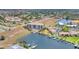 Aerial view of condo building in waterfront community with boat dock, boat, grass, landscaping, and community pool nearby at 1349 Aqui Esta Dr # 143, Punta Gorda, FL 33950