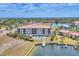 Beautiful condo building in waterfront community with boat dock, boat, grass, landscaping, and community pool nearby at 1349 Aqui Esta Dr # 143, Punta Gorda, FL 33950