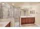 Spacious bathroom featuring a glass-enclosed shower and double sink vanity with wooden cabinets at 1349 Aqui Esta Dr # 143, Punta Gorda, FL 33950
