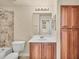 Bathroom featuring neutral tile, wooden cabinets, a tub, and a shower at 1349 Aqui Esta Dr # 143, Punta Gorda, FL 33950