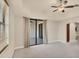 Bedroom with carpet, sliders to a balcony, large window, and view into the hallway at 1349 Aqui Esta Dr # 143, Punta Gorda, FL 33950