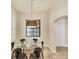 Dining area with modern chandelier, dark wood trim, and a glass table with six chairs at 1349 Aqui Esta Dr # 143, Punta Gorda, FL 33950