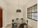Bright dining area with modern lighting and a glass-topped table with seating for six at 1349 Aqui Esta Dr # 143, Punta Gorda, FL 33950