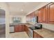 Kitchen featuring granite countertops, wood cabinets, and stainless steel appliances at 1349 Aqui Esta Dr # 143, Punta Gorda, FL 33950
