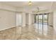 Spacious, neutral-toned living room featuring tile flooring and access to an outdoor balcony at 1349 Aqui Esta Dr # 143, Punta Gorda, FL 33950