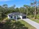 Aerial view of a well-maintained home with a neatly paved driveway, nestled amidst a lush green landscape at 14009 Daniels Ave, Port Charlotte, FL 33953