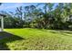 Large backyard featuring green grass and trees, providing ample space for recreation and outdoor activities at 14009 Daniels Ave, Port Charlotte, FL 33953