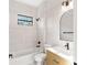 Modern bathroom features white tile surround, a sleek vanity, and minimalist finishes at 14009 Daniels Ave, Port Charlotte, FL 33953