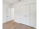 Minimalist bedroom showcasing hardwood floors and a closet with modern doors at 14009 Daniels Ave, Port Charlotte, FL 33953