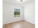 Minimalist bedroom with hardwood floors, white walls, and a bright window view at 14009 Daniels Ave, Port Charlotte, FL 33953