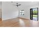 Bright bedroom with hardwood floors, modern ceiling fan, and natural light from doorway at 14009 Daniels Ave, Port Charlotte, FL 33953