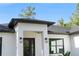 Stunning home exterior showcasing modern design with a black roof, black trim, and a clean white facade at 14009 Daniels Ave, Port Charlotte, FL 33953