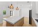 Bright kitchen with large island, modern lighting, and sleek black refrigerator at 14009 Daniels Ave, Port Charlotte, FL 33953