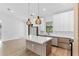 Open-concept kitchen featuring waterfall island, modern lighting, and stainless steel appliances at 14009 Daniels Ave, Port Charlotte, FL 33953