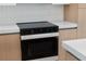 Updated kitchen with a modern stovetop, light wood cabinets, and quartz countertops at 14009 Daniels Ave, Port Charlotte, FL 33953
