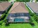Aerial view of a home featuring a screened-in pool and patio area surrounded by lush landscaping and green lawn at 15037 Montello Way, Lakewood Ranch, FL 34211