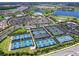 Aerial view of community amenities showcasing tennis and pickleball courts, clubhouse, parking, and landscaping at 15037 Montello Way, Lakewood Ranch, FL 34211