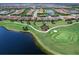 Wide aerial view of home, golf course and surrounding neighborhood with golf cart path and lake at 15037 Montello Way, Lakewood Ranch, FL 34211
